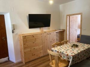 a room with a table and a television on a cabinet at Casa vacanza Emi in Bocenago