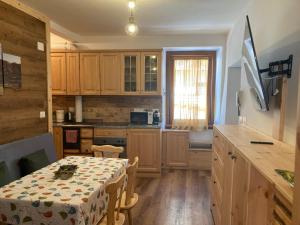 a kitchen with a table and a kitchen with wooden cabinets at Casa vacanza Emi in Bocenago