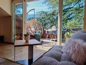 a living room with a couch and a large window at Mansarde Zeder in Privatvilla im Zentrum Merans in Merano