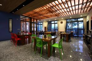 a dining room with tables and chairs and windows at 花蓮知卡宣民宿 in Ji'an