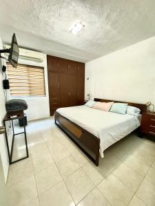 a bedroom with a large bed and a chair at Comfort and Privacy in Mérida