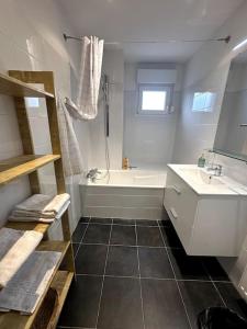 a bathroom with a white tub and a sink at A2 pas de Colmar terrasse,parking in Wintzenheim