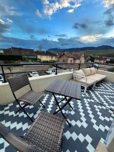 a patio with two chairs and a couch on a roof at A2 pas de Colmar terrasse,parking in Wintzenheim