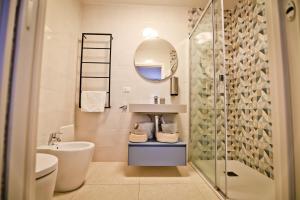 bagno con lavabo, servizi igienici e specchio di Bovio 33 Napoli art apartment a Napoli