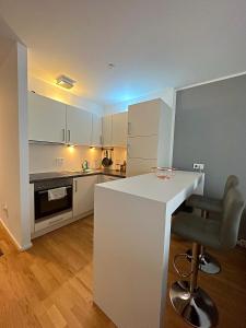 a kitchen with a white counter and a chair at CityLife Apartments Stuttgart Europa Viertel in Stuttgart