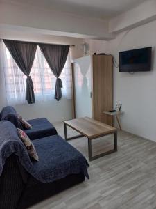 a living room with a bed and a table at Happiness Apartment Center in Bitola