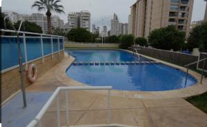 una grande piscina blu nel mezzo di una città di Bonito apartamento de la playa a Villajoyosa