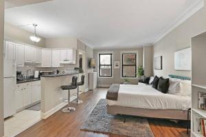 a large bedroom with a bed and a kitchen at Prime Studio Fully Furnished Apartment - Windermere 609 in Chicago