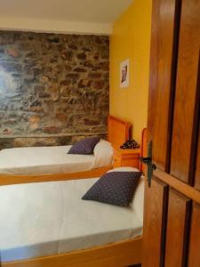 a room with two beds and a stone wall at Apartamento cerca de Bilbao in Basauri