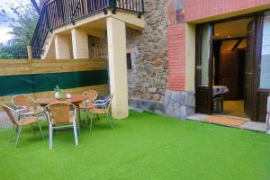 een tafel en stoelen op een patio met groen gras bij Apartamento cerca de Bilbao in Basauri