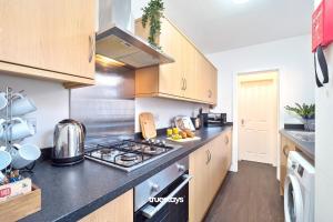 a kitchen with a stove and a counter top at Nursery House by Truestays - 3 Bedroom House in Stoke-on-Trent in Stoke on Trent
