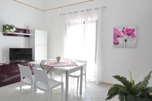 uma sala de jantar branca com uma mesa e cadeiras em Terrazza del Cortile - by Vacation Service em Cefalù