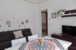 een woonkamer met een bank en een tafel bij Terrazza del Cortile - by Vacation Service in Cefalù