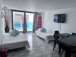 a room with two beds and a flat screen tv at Apartamento En San Andres in San Andrés