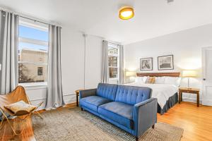 - une chambre avec un lit et un canapé bleu dans l'établissement Library Square Suites, à Toledo