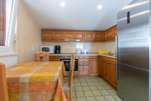 a kitchen with a table and a stainless steel refrigerator at Guest house Lenka in Brela