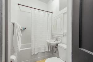 a white bathroom with a sink and a toilet at Library Square Suites in Toledo