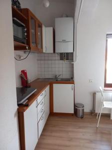 a kitchen with white cabinets and a wooden floor at Apartman Meda in Varaždin