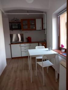 uma cozinha com uma mesa branca e cadeiras num quarto em Apartman Meda em Varaždin