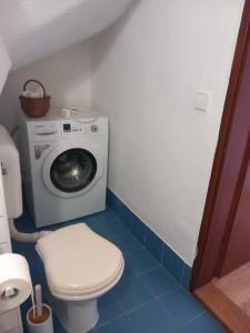 a bathroom with a washing machine and a toilet at Apartman Meda in Varaždin