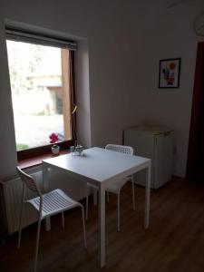 Biały stół i krzesła w pokoju z oknem w obiekcie Apartman Meda w mieście Varaždin