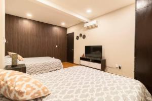 a bedroom with two beds and a flat screen tv at 401 Location 3Bdrm 2bath apt with AC Rooftop in Mexico City