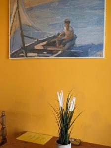 une peinture d'un homme dans un bateau sur l'eau dans l'établissement Panorama Inn, à Lithakia
