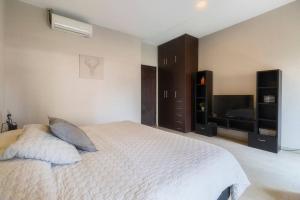 a bedroom with a white bed and a television at 304 Balcony apt Walk to Zocalo AC Rooftop in Mexico City