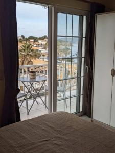 a bedroom with a bed and a balcony with a table at Panorama Inn in Lithakia