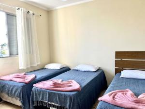 duas camas num quarto com toalhas cor-de-rosa em Apartamento Mobiliado em Piracicaba Centro em Piracicaba