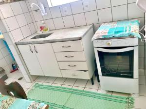 uma pequena cozinha com um fogão e um lavatório em Apartamento Mobiliado em Piracicaba Centro em Piracicaba