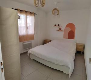 a bedroom with a white bed and a window at Chez Roberto/Jardin/Parking in Fos-sur-Mer