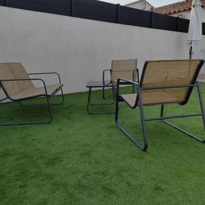 two chairs and a table in a room with grass at Chez Roberto/Jardin/Parking in Fos-sur-Mer