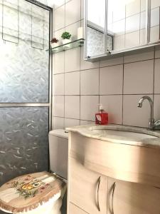 uma casa de banho com um lavatório, um chuveiro e um WC. em Apartamento Mobiliado em Piracicaba Centro em Piracicaba