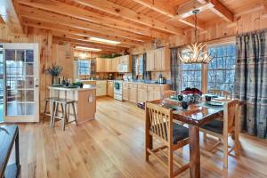 3-Storey Home with Gorgeous Deck on Bows Lake ➠ 9776 في Boyne Falls: مطبخ كبير مع طاولة وكراسي في كابينة