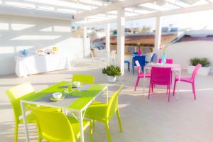 a patio with colorful tables and chairs in a building at Stanze del Mare in Balestrate