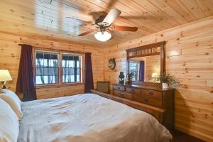 a bedroom with a bed and a ceiling fan at 3-Storey Home with Gorgeous Deck on Bows Lake ➠ 9776 in Boyne Falls