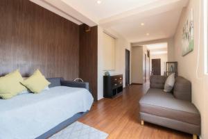 a bedroom with a bed and a couch and a chair at 406 Location 2Bdrm 2baths AC Rooftop in Mexico City +41 photos