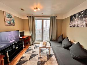 a living room with a couch and a flat screen tv at Entire Apartment next to Canary Wharf in London in London