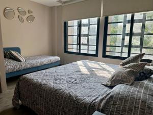 a bedroom with two beds and two windows at 202 Walk the City Center 1bdrm 2bath AC Apt in Mexico City