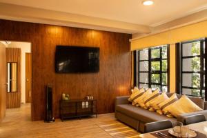 a living room with a couch and a television on a wall at 202 Walk the City Center 1bdrm 2bath AC Apt in Mexico City