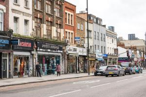 a busy city street with cars parked in front of stores at Ideal 1BD Flat Shoreditch For City Explorers in London