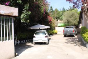 two cars parked in a driveway with an umbrella at Kind private room 8 in Addis Ababa