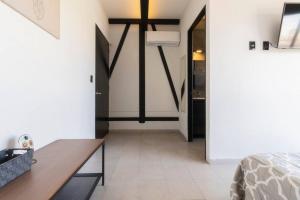 a bedroom with white walls and a table and a bed at 2Ph Large 2Brm 3 bath AC private terrace apt in Mexico City