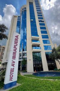 un edificio alto con un cartel delante en Suíte 5 estrelas Hotel Av Ibirapuera 2534 Piscina, en São Paulo