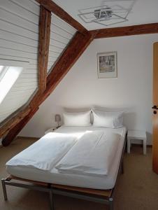 a bedroom with a white bed in a attic at Hotel Anker in Rottenburg