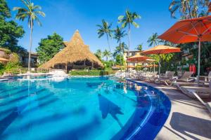 Una piscina en un resort con sillas y sombrillas. en Hacienda Buenaventura Hotel & Mexican Charm - All Inclusive, en Puerto Vallarta