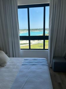 sypialnia z łóżkiem i widokiem na ocean w obiekcie Hermoso Apart @the Beach Punta Cana w Punta Cana