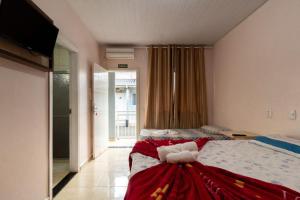 Un dormitorio con una cama con un vestido rojo. en Hotel Bahamas - Foz do Iguacu, en Foz do Iguaçu