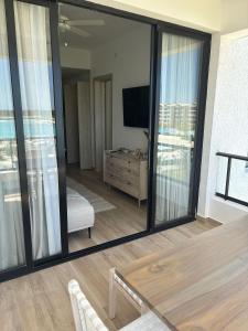uma sala de estar com uma grande janela de vidro e uma televisão em Hermoso Apart @the Beach Punta Cana em Punta Cana